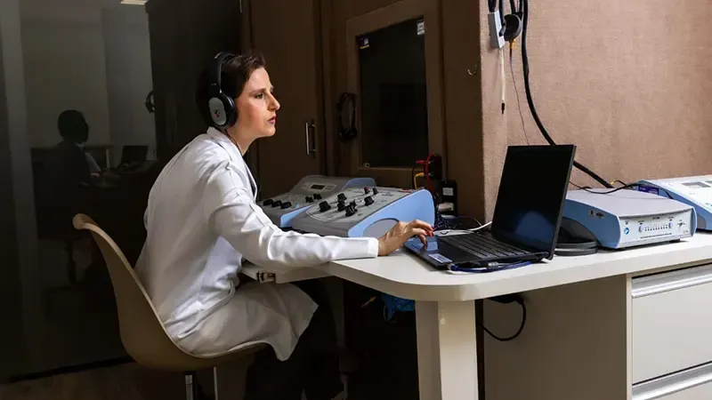 Fonoaudióloga do INAB no posto de audiometria, ao lado da cabine acústica